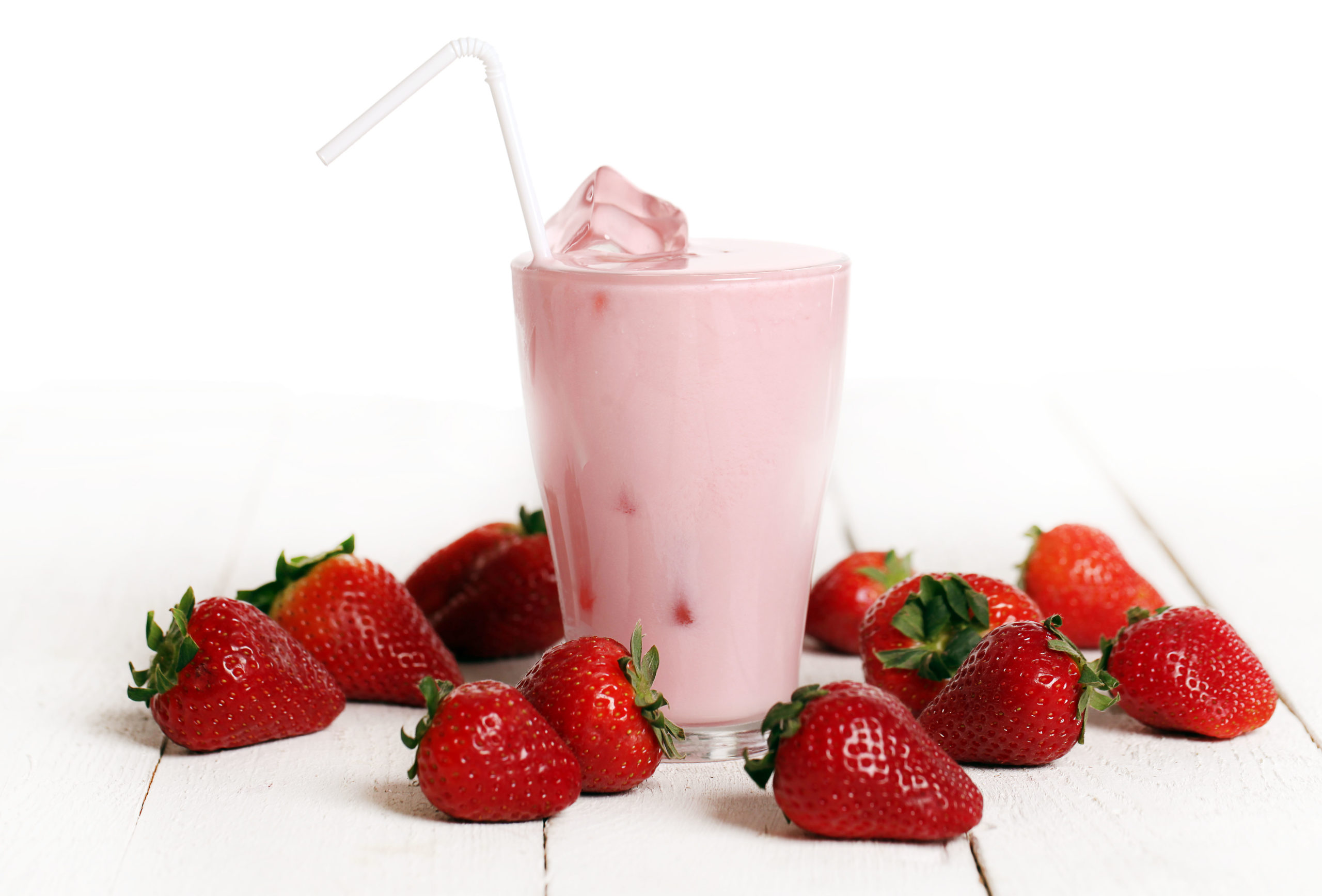 Iced strawberry pink cocktail in a glass and strawberries