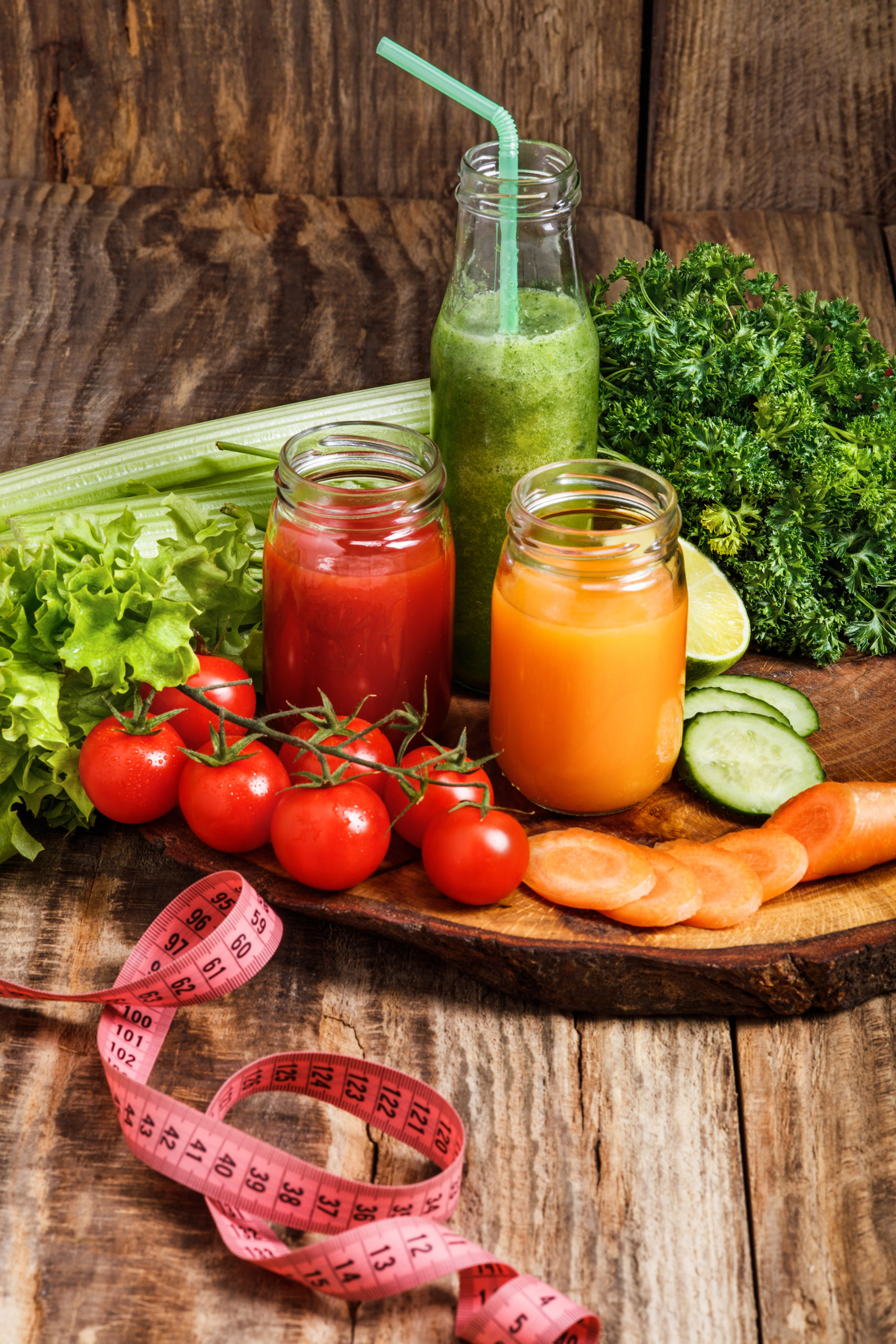 The bottles with fresh vegetable juices on wooden table. Detox diet.